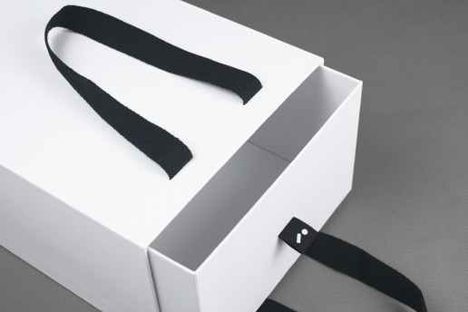 Коробка — пакет с ручками из картона, хлястик с логотипом